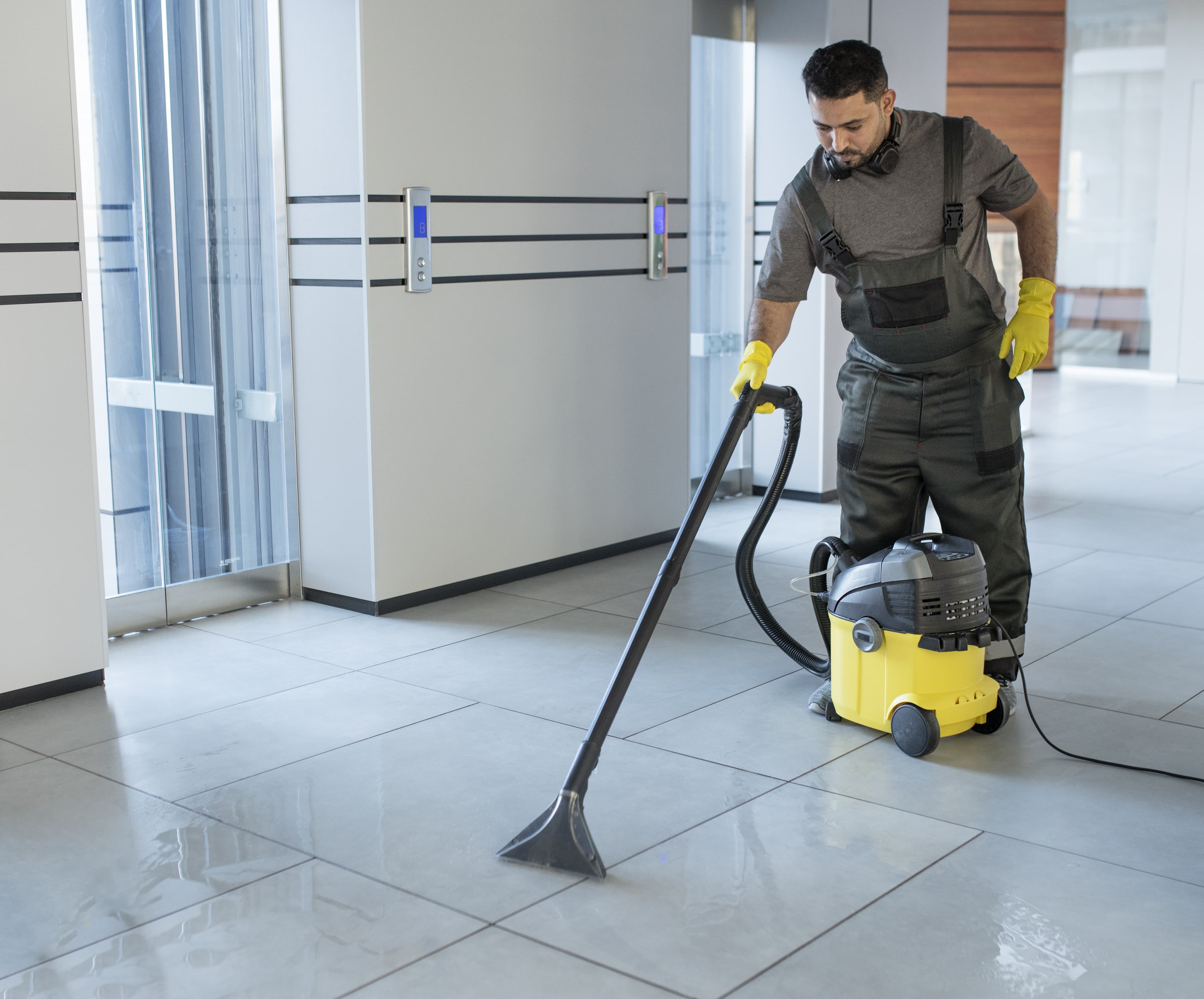 Full shot man vacuuming office floor